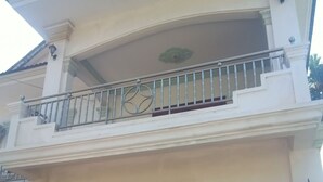 A two-story building with a balcony, a wooden door, and a small Christmas tree. - The Crocodile villa (Siem Reap)