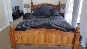 A bed with a wooden headboard, black and white striped bedding, and two bedside lamps.