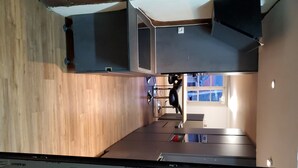 A modern kitchen with wooden flooring, built-in appliances, and a window providing natural light.