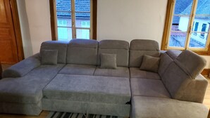 A grey sectional sofa with a striped rug in front.