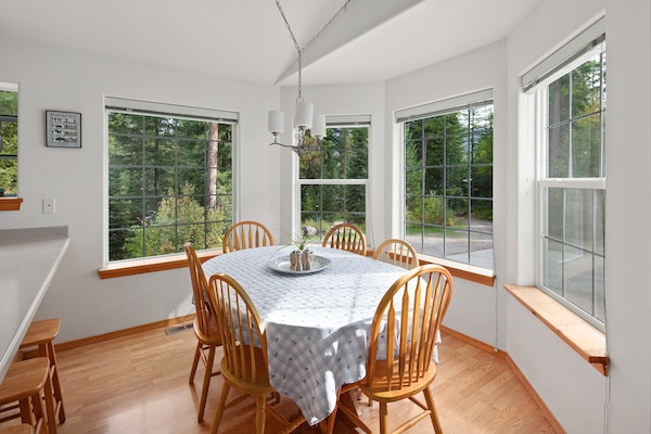 The dining room has large windows in a bay shape.