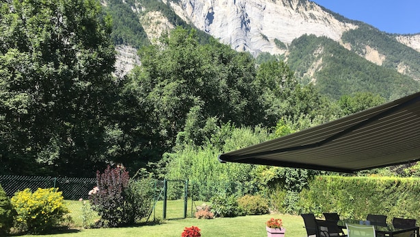 Un espace extérieur aménagé avec des sièges et une vue sur une montagne.