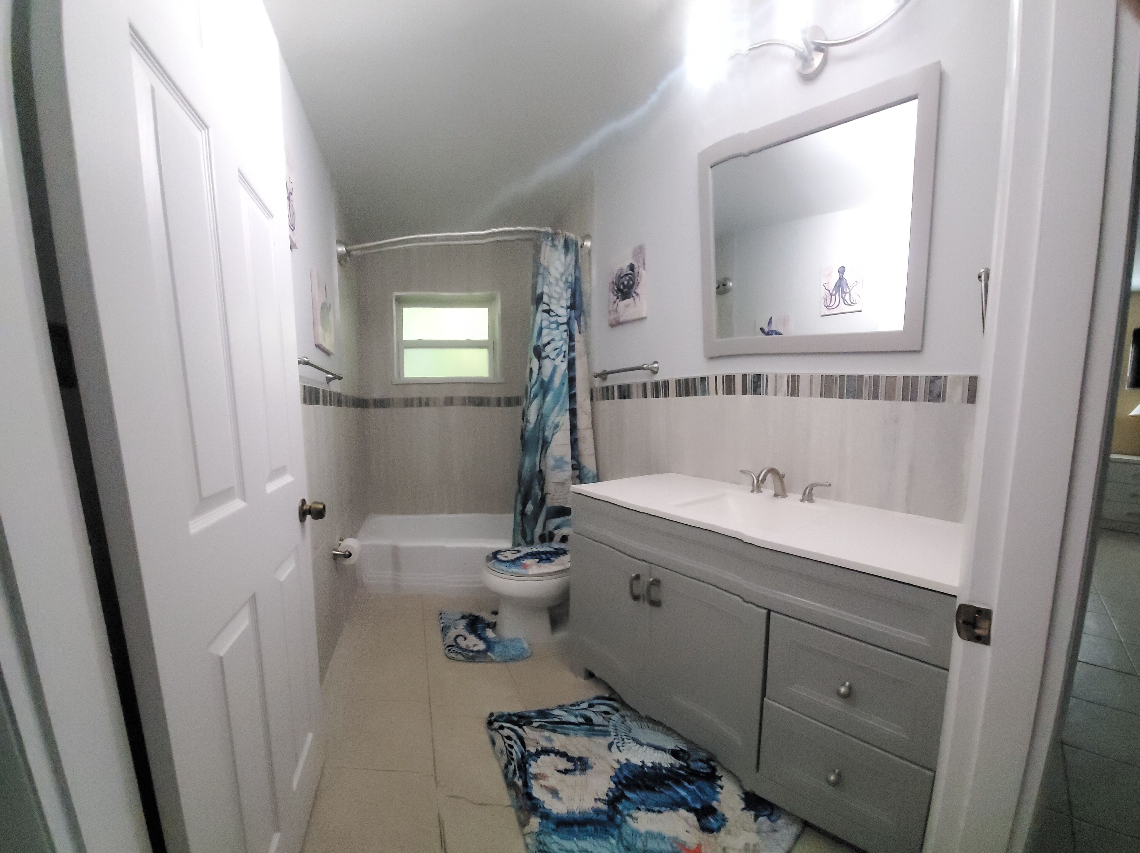 A bathroom with a bathtub, toilet, and sink.