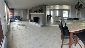 A spacious living area with a dining table, sofas, and a fireplace. - Waterfront house in South Ft Myers on Whiskey creek (Fort Myers)