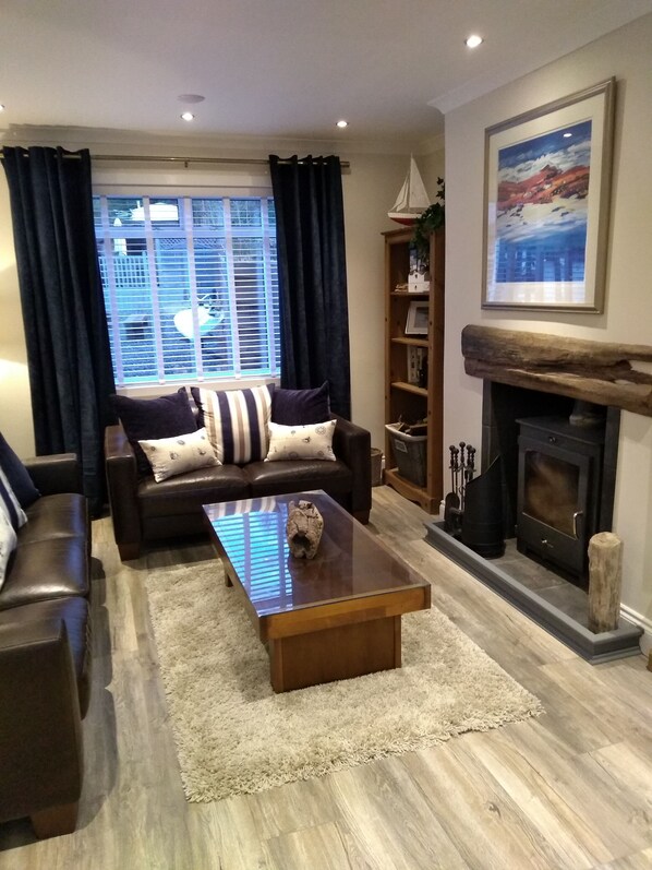 A living room with a sofa, coffee table, and fireplace.