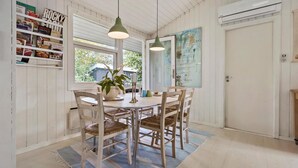 A dining area with a round table, four chairs, a potted plant, and a map on the wall. - 4 bedroom amazing home in Hornbæk (Hornbæk)