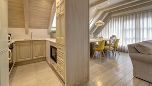Une cuisine moderne avec des meubles en bois et un coin repas doté de chaises jaunes.