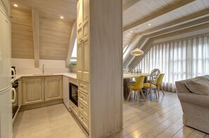 Una cucina moderna con mobili in legno e un'area pranzo con sedie gialle.