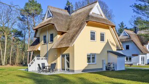 Et hus med et unikt arkitektonisk design, kendetegnet ved en stor taghældning og en del med stråtækkede tage.