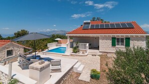 A villa with a swimming pool, outdoor seating, and solar panels on the roof. - Cozy home in Pucisca with private swimming pool, can be inside or outside (Pucisca)