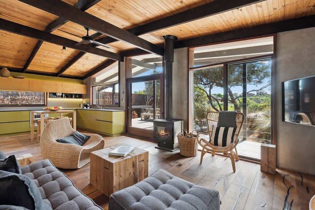 A spacious living area with a fireplace, large windows, and a view of the outdoors.