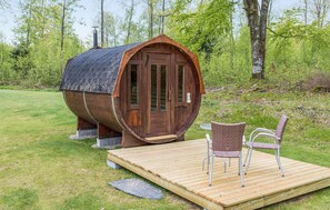Relax in a rustic barrel accommodation surrounded by lush greenery.