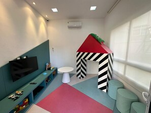 A children's play area with a TV, playhouse, and seating. - Compacto de Luxo - Helbor My Way (Fortaleza)