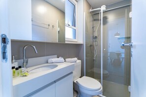 A modern bathroom with a glass shower enclosure, a white sink, and a toilet. - Compacto de Luxo - Helbor My Way (Fortaleza)