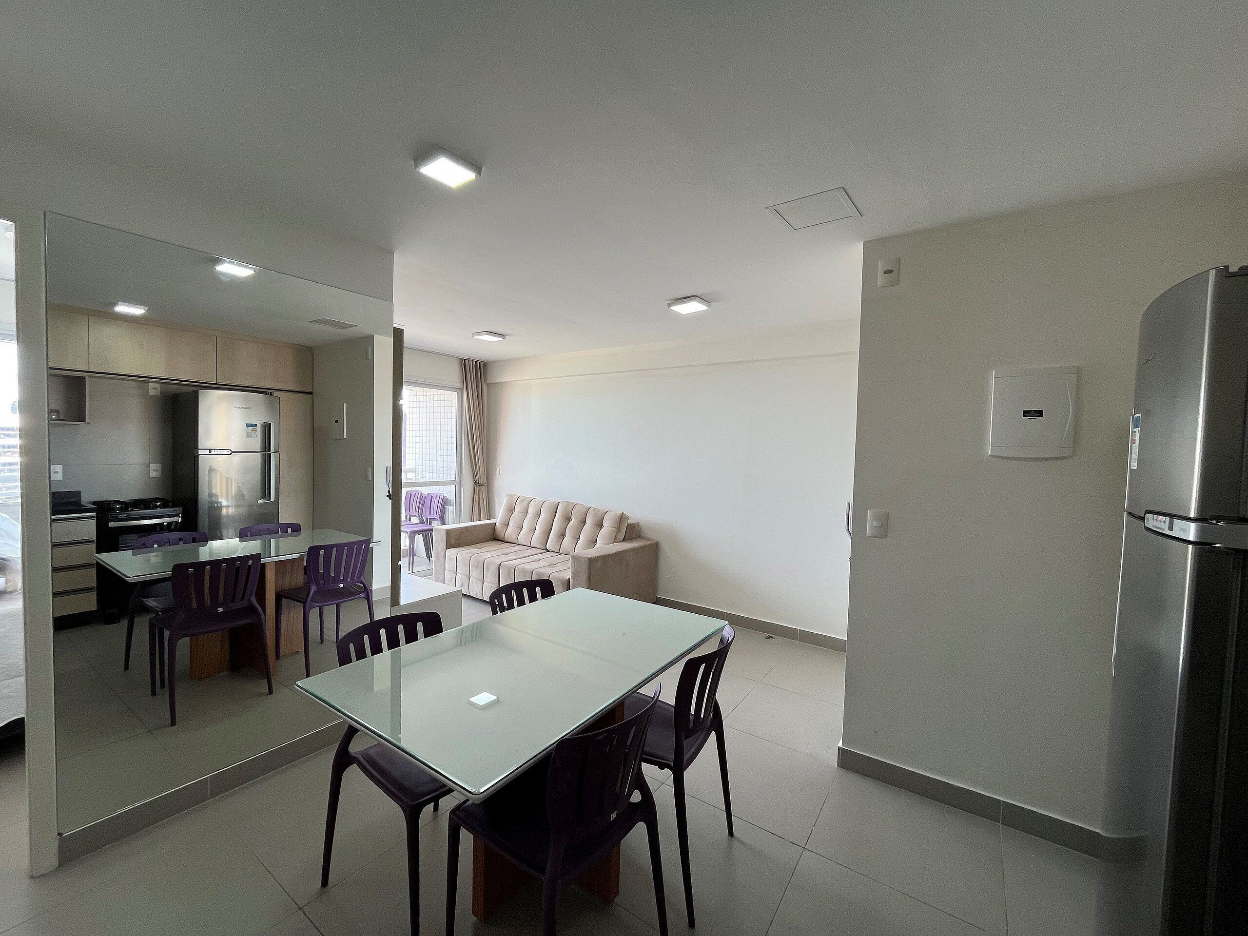 Una cocina moderna con comedor, sofá y refrigerador.