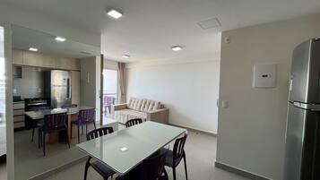 Una cocina moderna con comedor, sofá y refrigerador.
