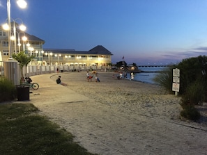 A beachside hotel with a large building, a paved walkway, and a view of the ocean.
