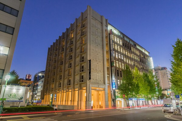 Experience the welcoming entrance of this hotel, featuring a prominent facade with balconies and large windows.