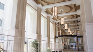 A spacious atrium with high ceilings, large windows, and modern chandeliers.