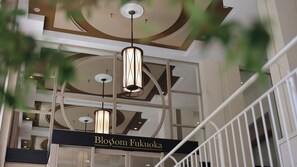Experience the sleek, modern design of Blossom Fukuoka, featuring a stunning chandelier and spacious balcony with a railing.