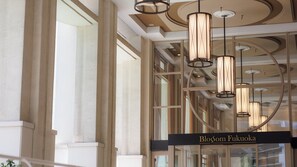 A modern interior with a glass facade, a sign reading "Blossom Fukuoka," and a series of cylindrical pendant lights. - JR KYUSHU HOTEL Blossom Fukuoka (Fukuoka)
