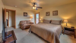 A bedroom with a bed, a chair, a desk, and a ceiling fan. - Canyon & Sky: Hot Tub Sanctuary, Redrock Patio Lounge, & Sunset Deck Views! SG2 (Moab)
