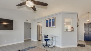 A spacious living area with a ceiling fan, a dining table, and a kitchen in the background. - Beautiful remodeled home to enjoy your stay. (Phoenix)