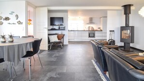 A modern kitchen with a flat-screen TV, a built-in oven, and a stove.