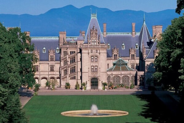 A large, historic building with a central courtyard and a fountain.