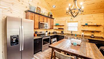 A compact kitchen with wooden cabinets, stainless steel appliances, and a central island.