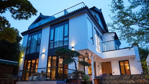 A modern two-story house with large windows, a stone pathway, and a well-lit entrance. - Floral Hotel Joyful Garden Hangzhou (Hangzhou)