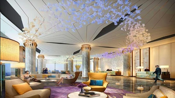 A spacious lobby with modern furniture, a central chandelier, and a unique ceiling design. - Oriental Ginza International Hotel (Dongguan)