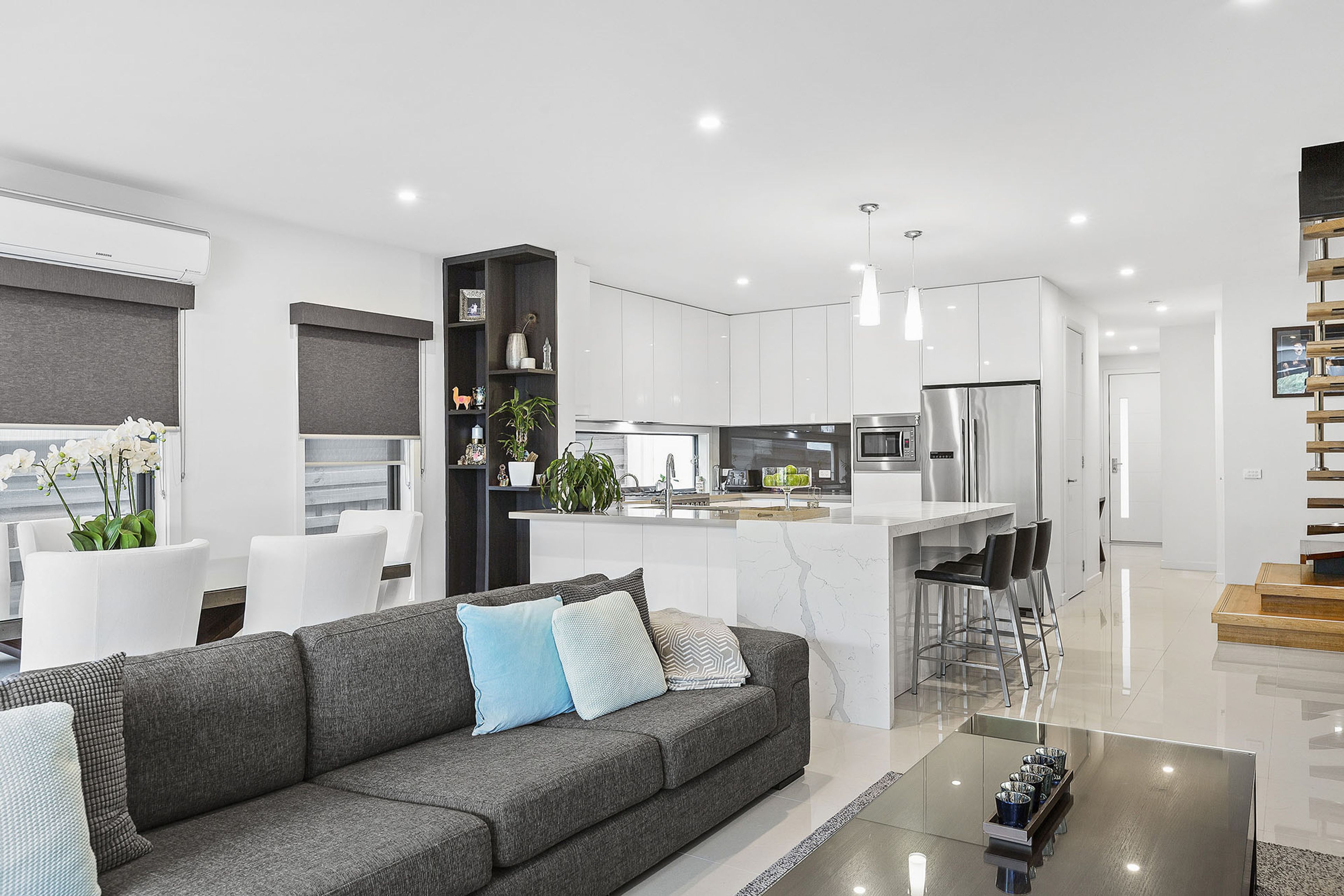 A modern kitchen with white cabinets, a central island, and stainless steel appliances.