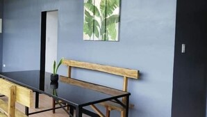 A modern interior with a long wooden bench, a black table, and a wall-mounted picture of leaves. - Tatay Seseng's Apartment  Panglao (Panglao)