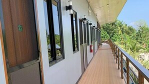 A corridor with a wooden floor, a green mat at the entrance, and a door marked with the number 22. - Tatay Seseng's Apartment  Panglao (Panglao)