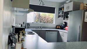 A modern kitchen with a dishwasher, sink, and a coffee maker.