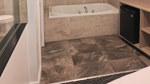 A modern bathroom with a bathtub, a shower area, and a toilet. - Super 8 by Wyndham Montreal (Montreal)