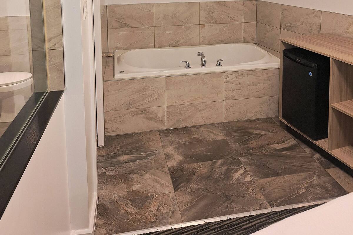 Ein modernes Badezimmer mit Badewanne, Duschbereich und Toilette.