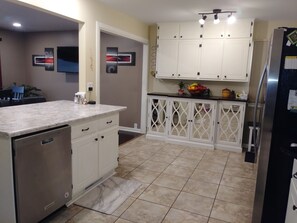 A kitchen with white cabinets, a marble countertop, and a stainless steel refrigerator. - 4BR/2BA Sturgis Rally 2020 Rental (Rapid City)