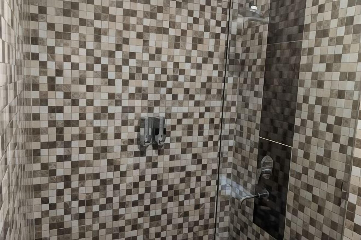 A tiled shower area with a checkered pattern.