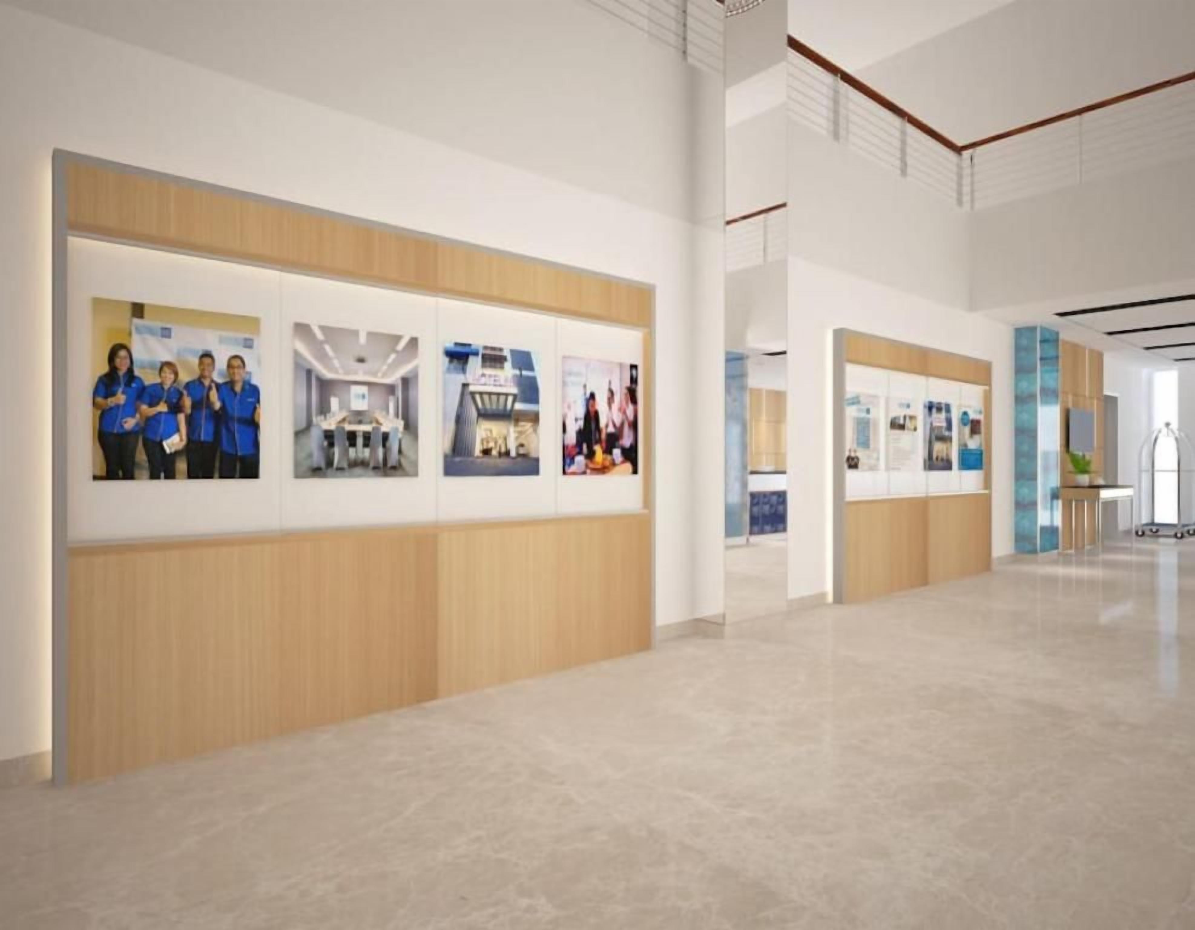 Een modern interieur met een lange receptiebalie, afbeeldingen in lijsten aan de muur en een schone, gepolijste vloer.