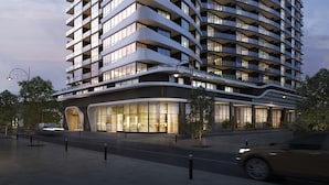 Ein modernes Mehrstöckhotel mit geschwungenen Balkonen und großen Fenstern.