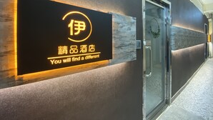 A hotel reception area with a modern sign featuring Chinese characters and English text. - Guest House Conext (Kowloon)