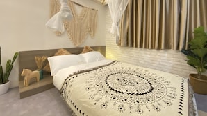 A bedroom with a bed, a canopy, macramé wall hangings, a cactus, and a potted plant. - Guest House Conext (Kowloon)