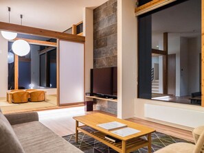 Relax in this stylish living room with a flat-screen TV and a large window offering a view.