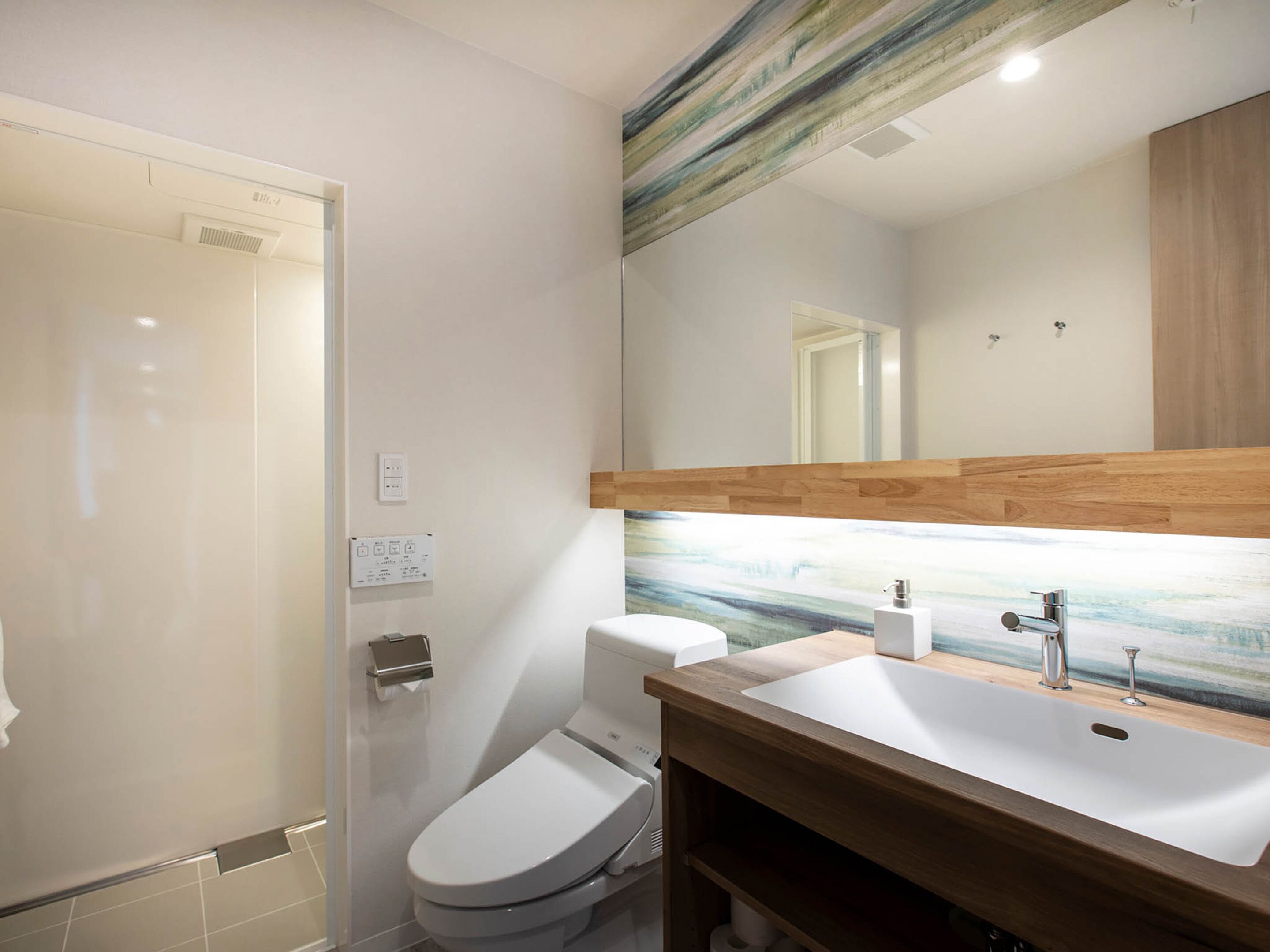 A modern bathroom with a toilet, sink, and shower.