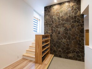 Contemporary space with a light-colored floor, wooden bookshelf, and sloped ceiling.