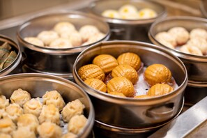 A variety of food items in metal bowls, likely a buffet setting.