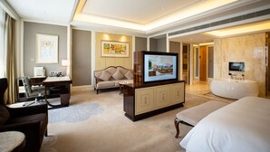 A modern hotel room with a large bed, a sofa, a desk with a computer, a television, and a bathtub. - Oriental Ventura (Lishui)