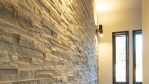 A hallway with a stone wall and wooden flooring. - Setsu (Fujikawaguchiko)